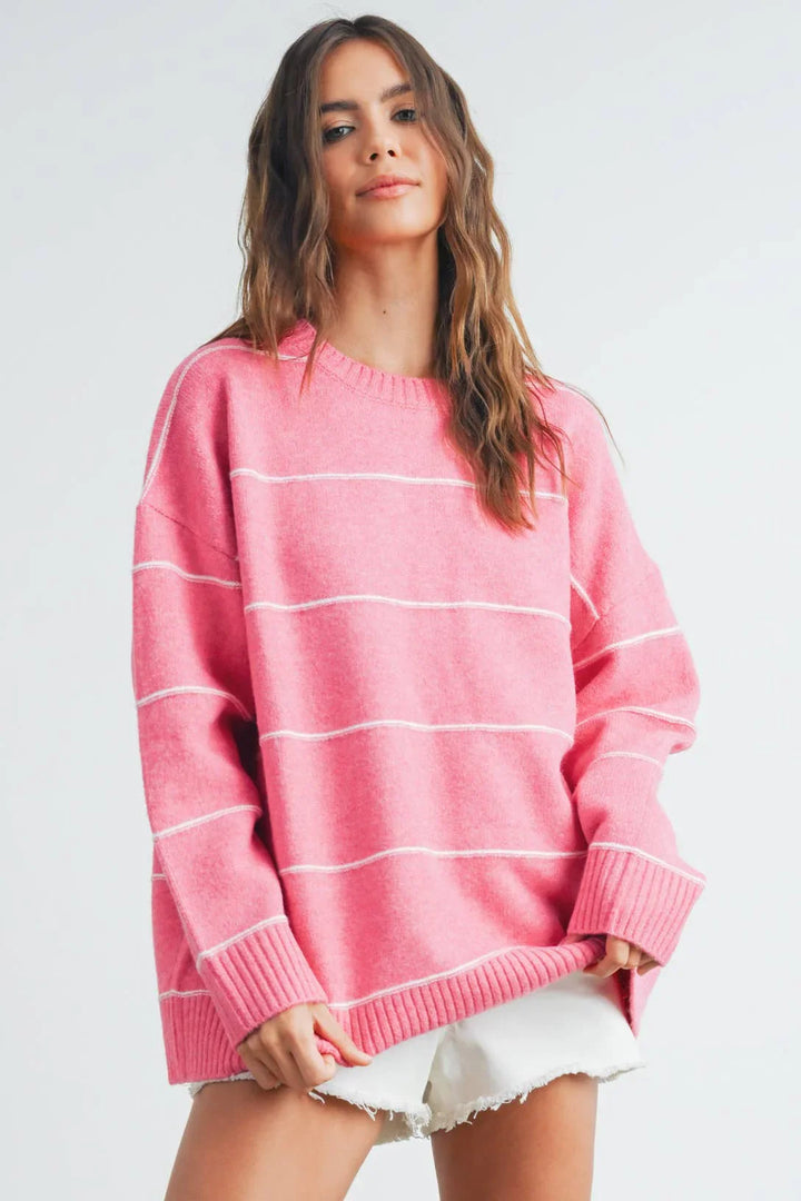 Pink striped oversized sweater with white ribbed cuffs and hem, paired with denim shorts