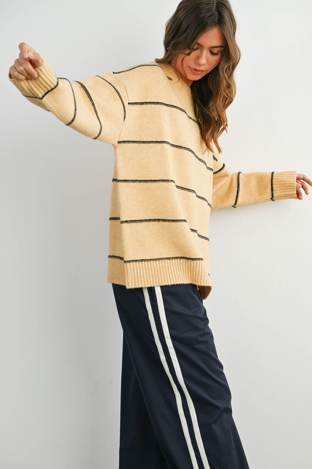 Woman in cozy yellow striped sweater and navy track pants, PNW outdoor style