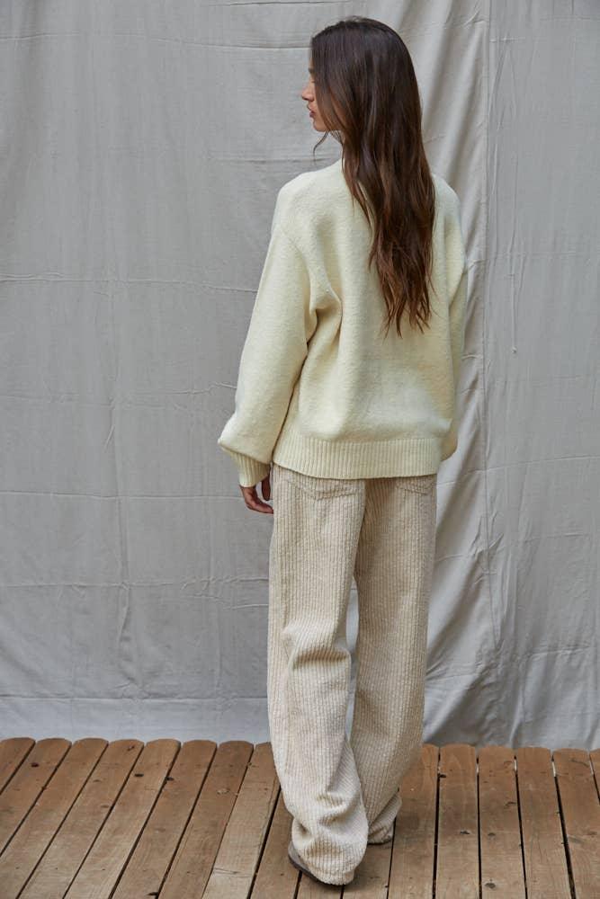 Cream oversized sweater and corduroy pants for cozy coastal style