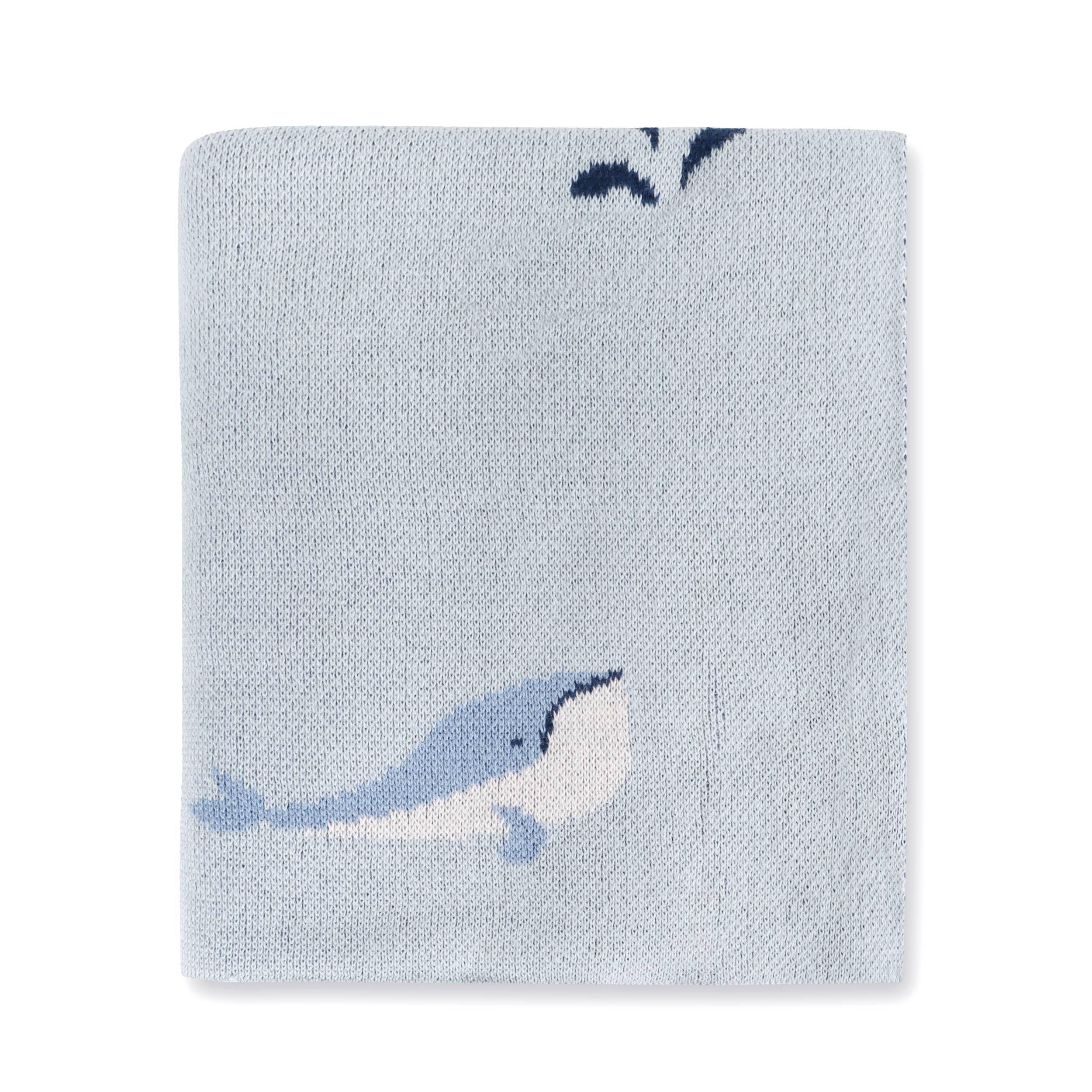 Light blue knitted blanket with whale design, soft texture, nautical theme