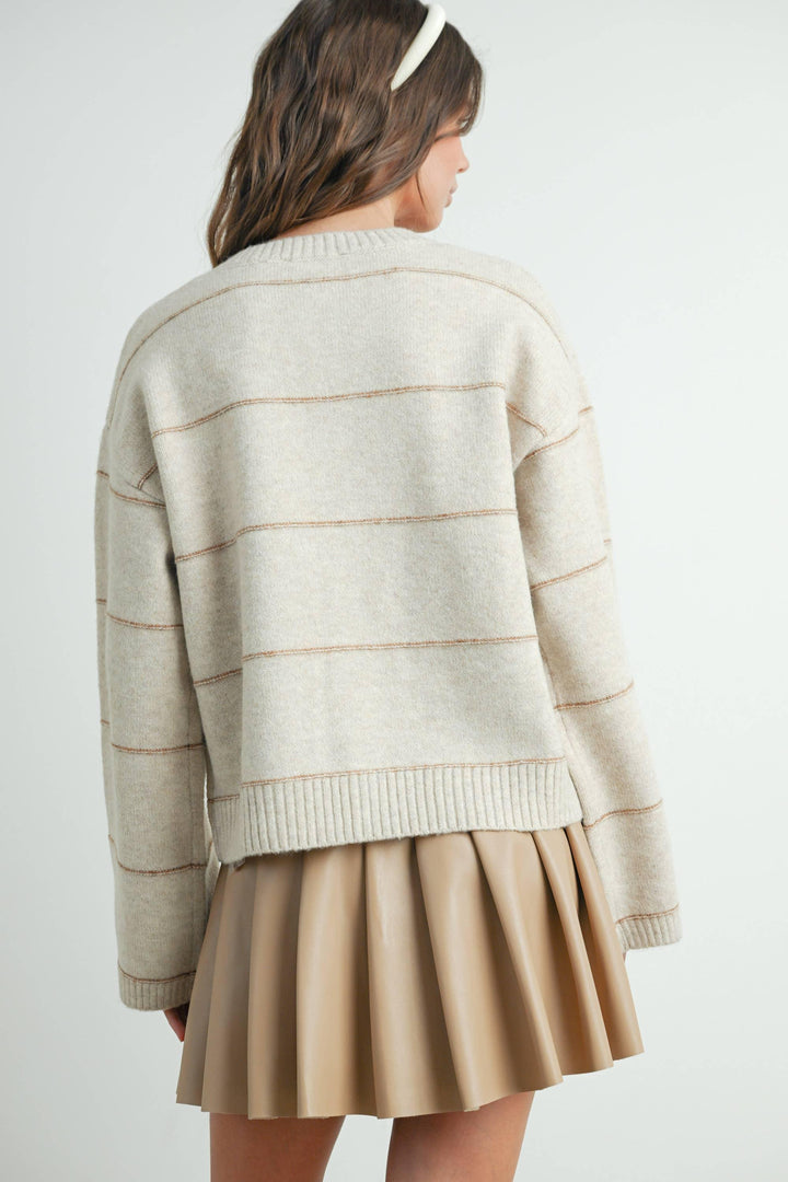 Cream striped knit sweater with ribbed hem, paired with tan pleated skirt, coastal style outfit