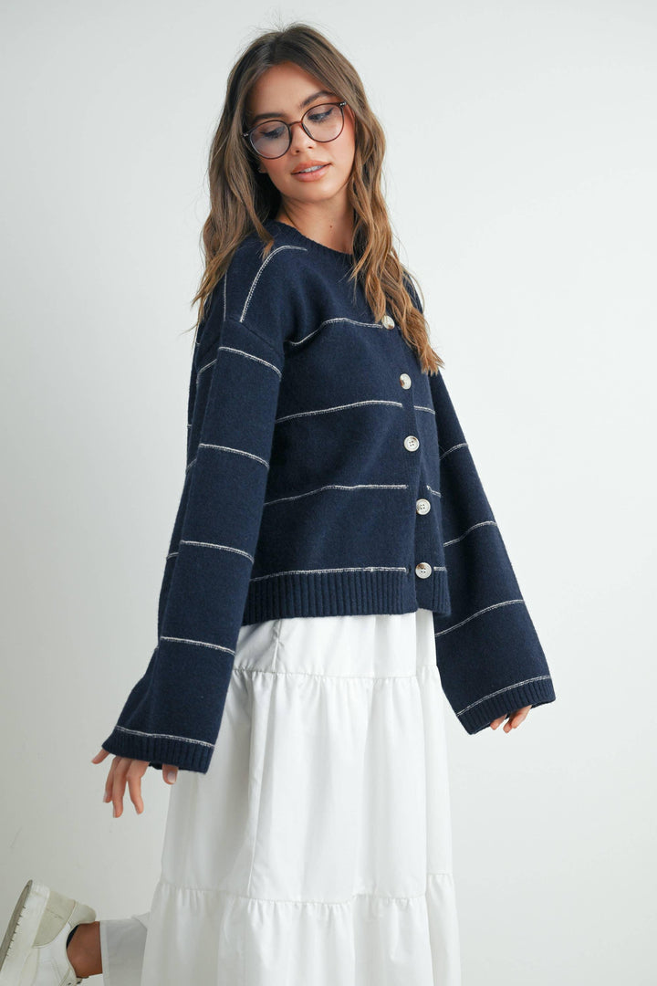 Navy blue striped button-up cardigan with bell sleeves, paired with white tiered skirt for coastal style