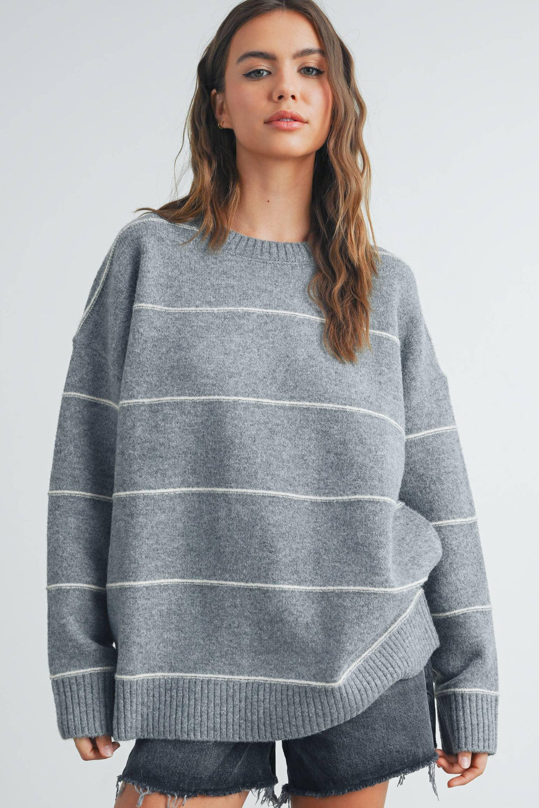 Grey striped oversized sweater with ribbed hem and cuffs, paired with denim shorts