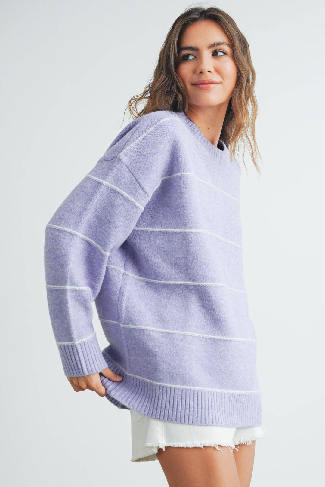 Lavender striped oversized sweater with ribbed hem and cuffs, paired with white denim shorts