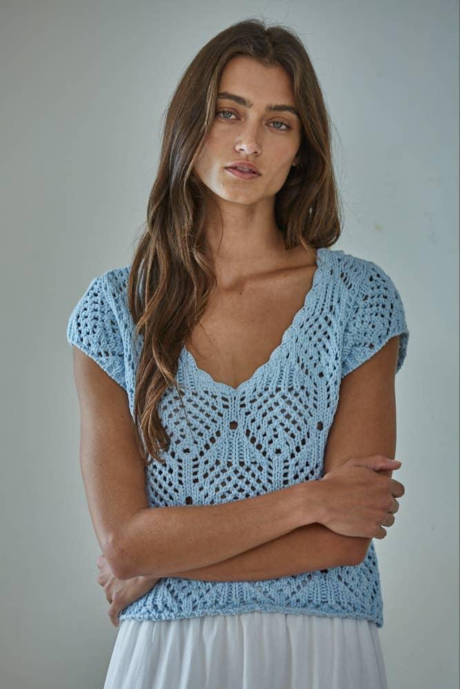 Light blue crocheted top with V-neck and short sleeves, paired with white skirt