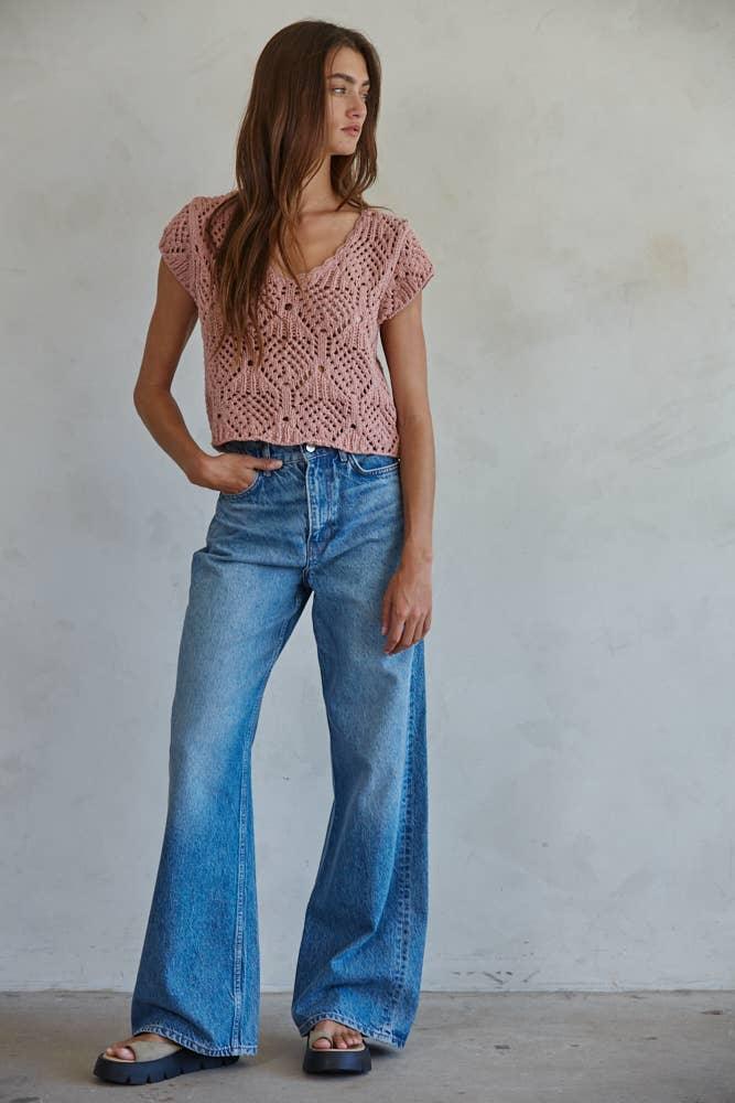 Woman wearing pink crochet top and wide-leg denim jeans, casual summer outfit