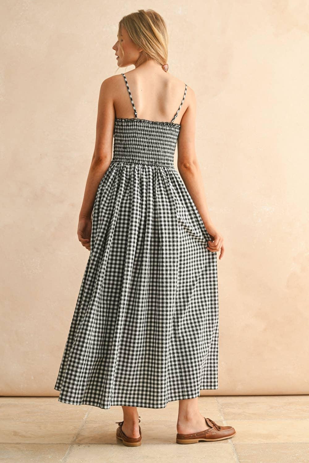 Black and white gingham maxi dress with smocked back and thin straps, paired with brown loafers