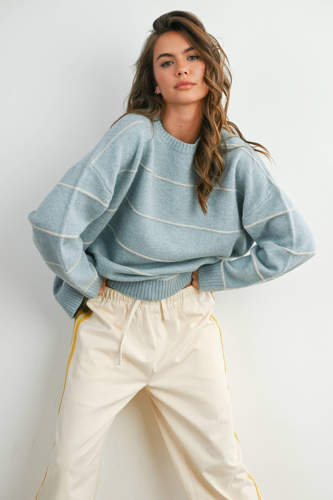 Woman in light blue striped sweater and cream joggers, coastal PNW style outfit