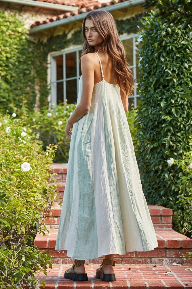 Woman in flowy mint maxi dress on brick steps, coastal garden setting, perfect for beach days and PNW weekends