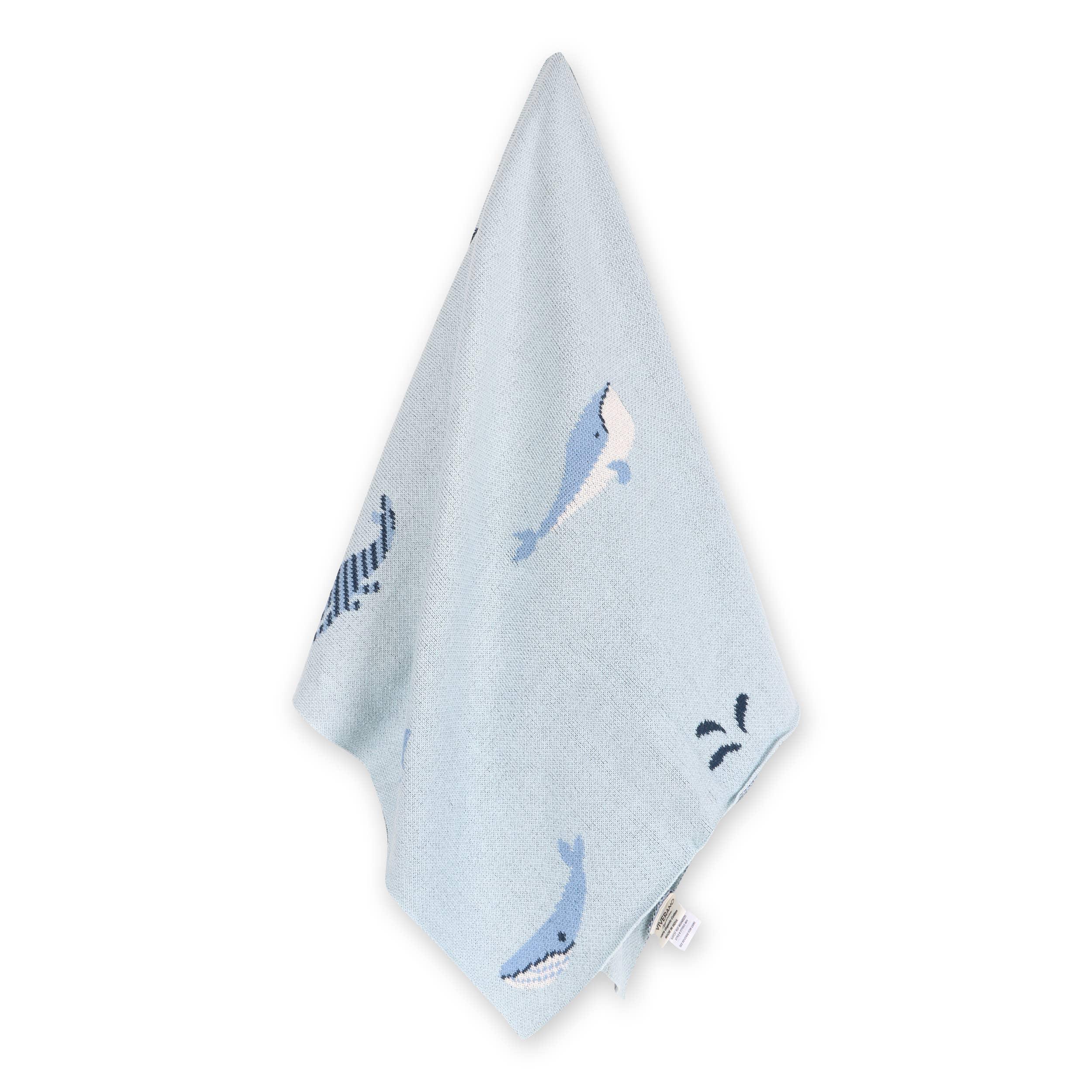 Light blue baby blanket with whale print, soft knitted fabric for nursery or travel