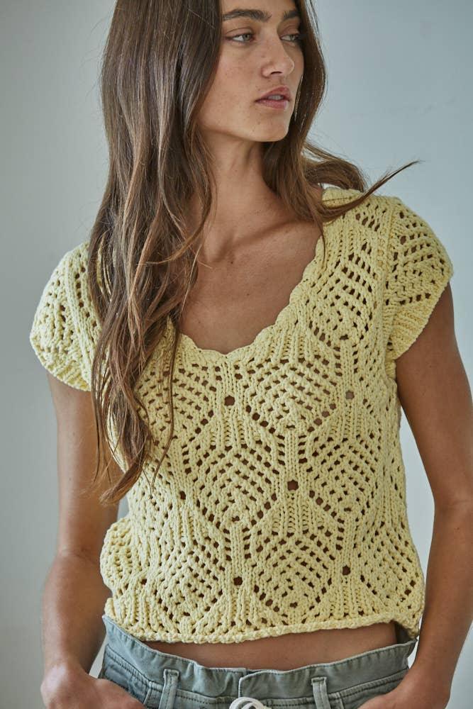 Lemon yellow crochet crop top with V-neck and short sleeves, paired with denim shorts