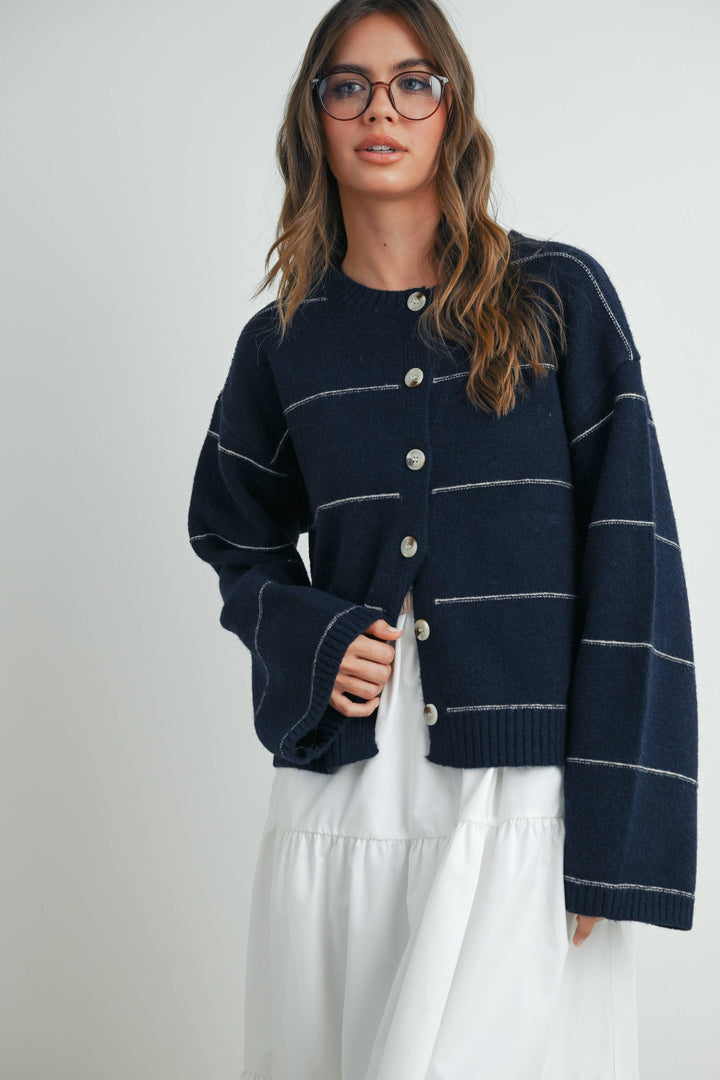 Navy blue striped cardigan with white contrast stitching and front buttons, styled with white dress for coastal PNW fashion