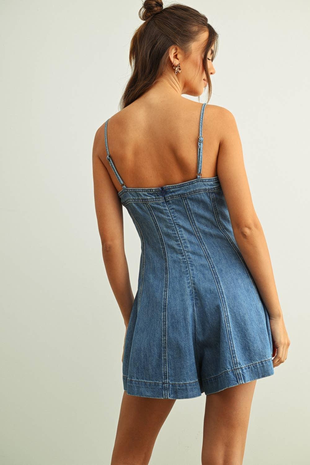 Woman wearing backless denim romper with thin straps and flared shorts, casual summer outfit