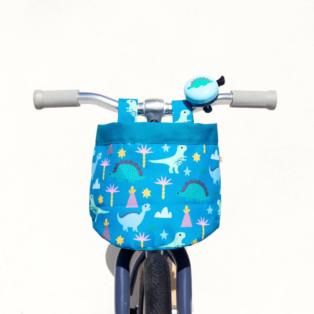 Kids bike with blue dinosaur print basket and matching bell, perfect for outdoor adventures