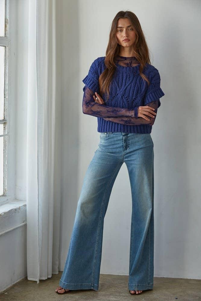 Woman in blue cable knit sweater with lace sleeves and wide leg jeans, coastal style outfit