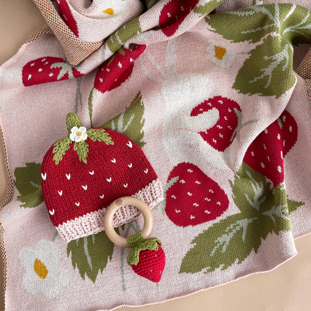 Strawberry-themed baby blanket with knit strawberry teether and rattle, perfect for coastal PNW adventures
