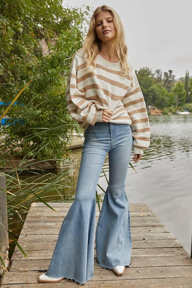 Woman in striped sweater and flared jeans on lakeside dock, coastal PNW style
