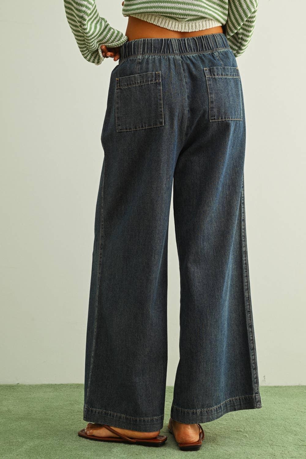 Wide-leg denim pants with elastic waist and back pockets, paired with striped top and sandals
