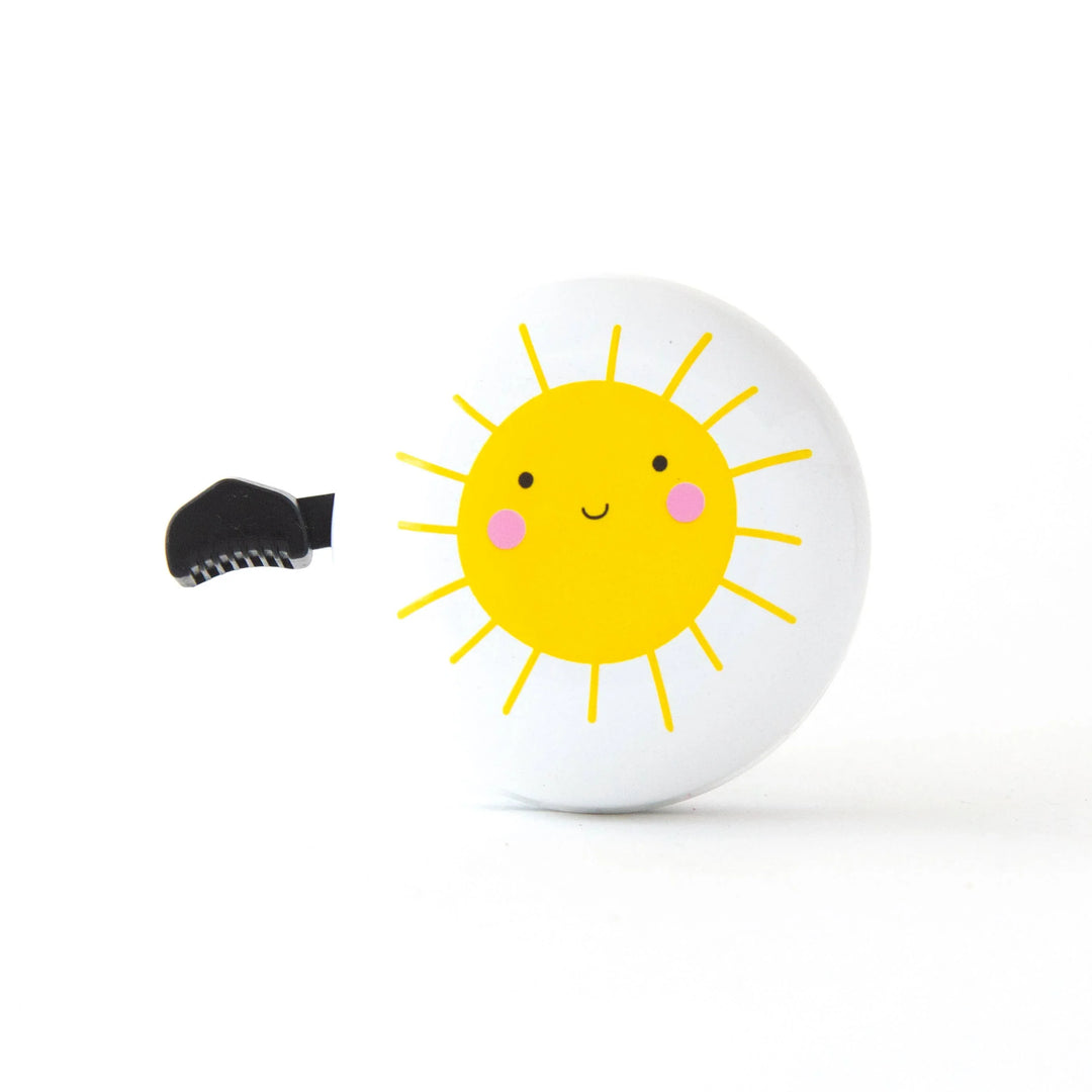 Cute sun-themed bike bell with cheerful yellow face and pink cheeks, perfect for coastal adventures.