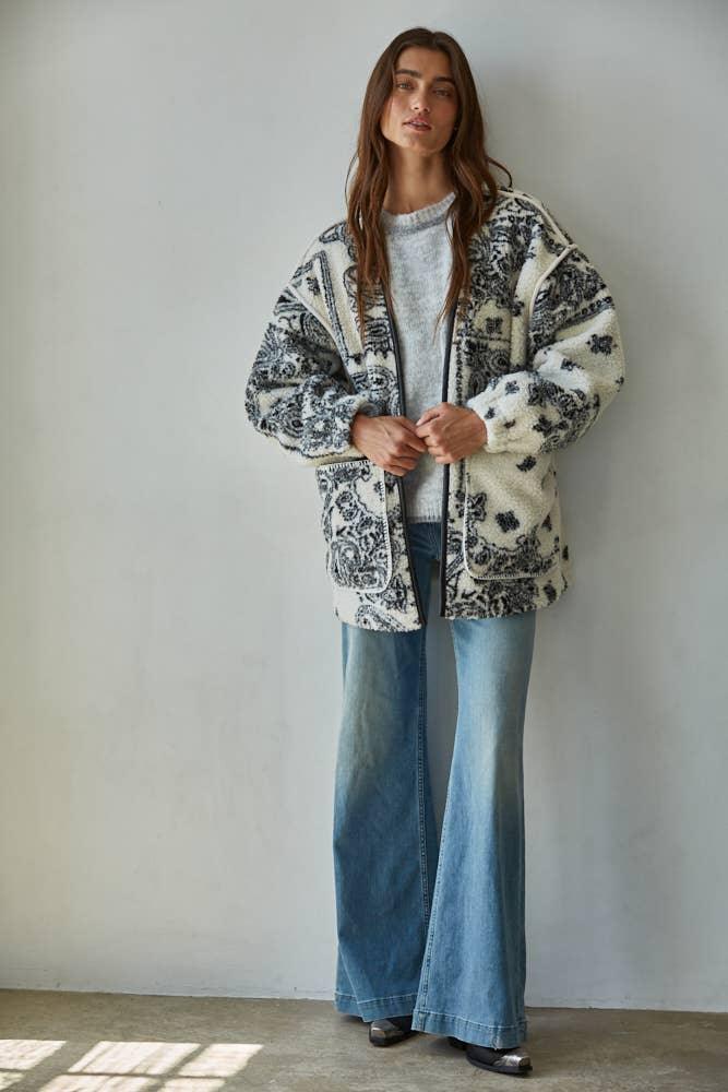 Cozy patterned fleece jacket with wide-leg jeans, perfect for PNW coastal style and outdoor adventures.