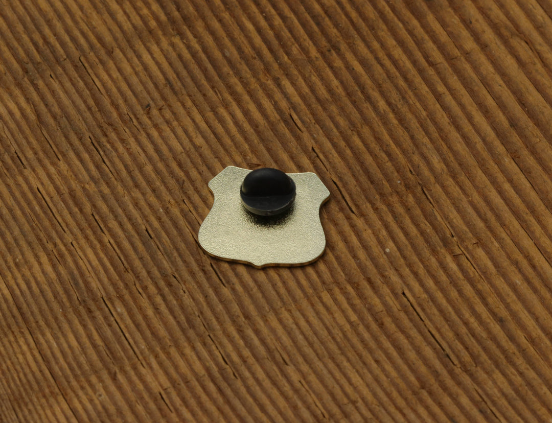 Metal board pin with black knob on wooden surface, ideal for basecamp board and bike organization