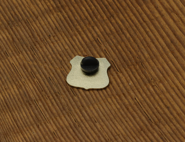 Metal board pin with black knob on wooden surface, ideal for basecamp board and bike organization