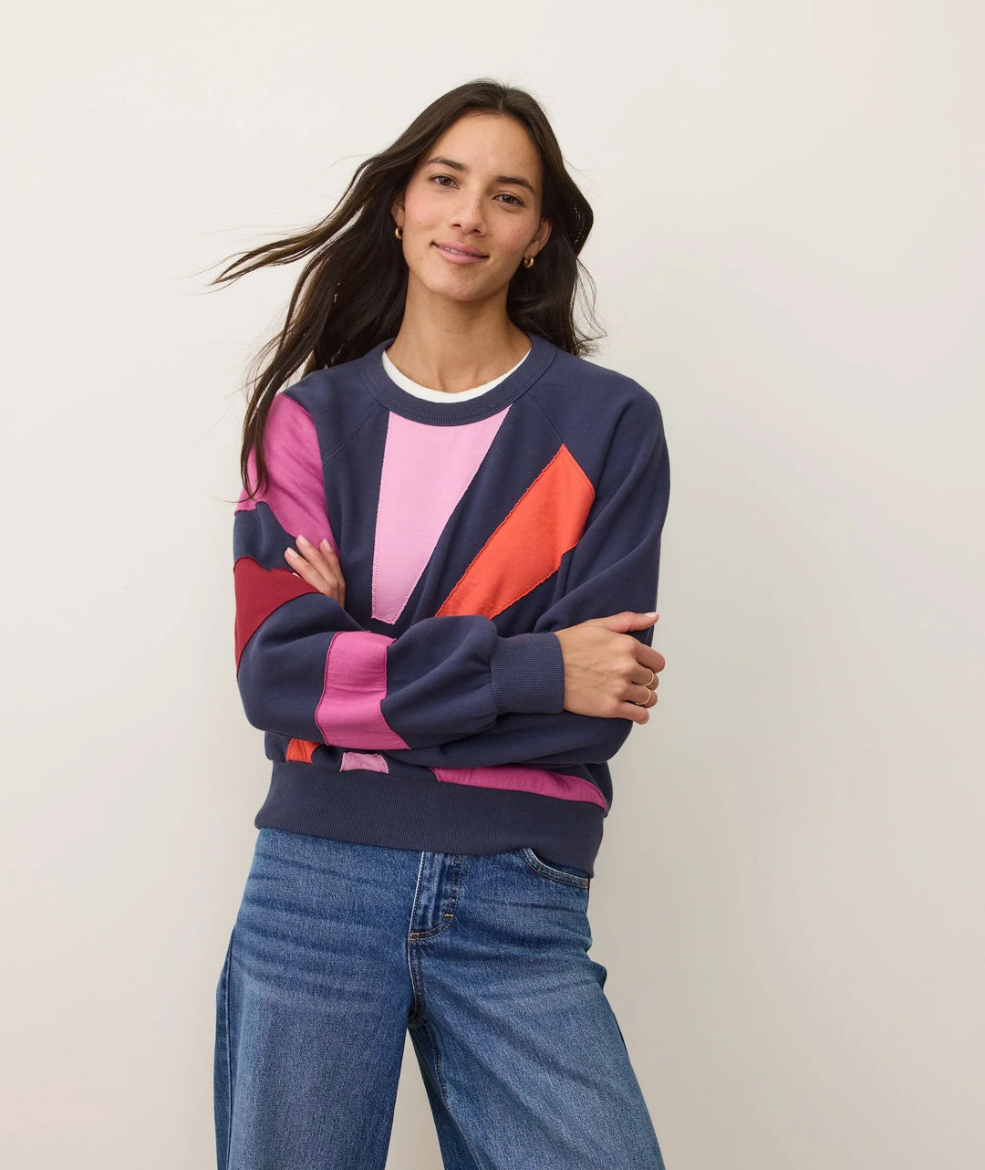 Woman in colorful patchwork sweatshirt and jeans, coastal outdoor style