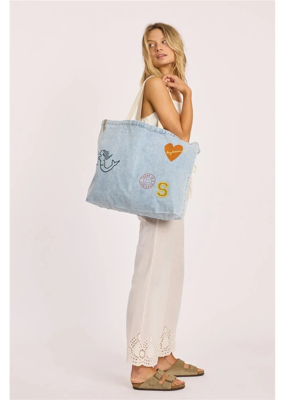Light denim tote bag with patches, perfect for beach days and coastal adventures
