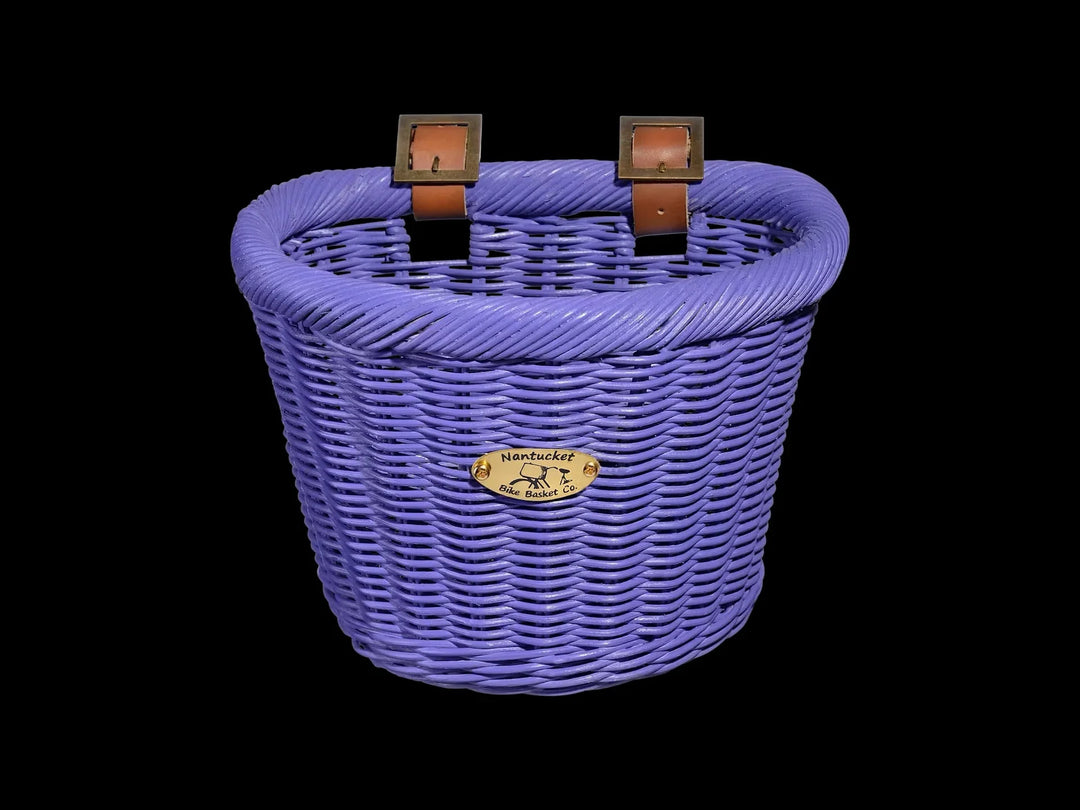 Purple woven bike basket with leather straps and Nantucket Bike Basket Co. plaque, perfect for coastal adventures.