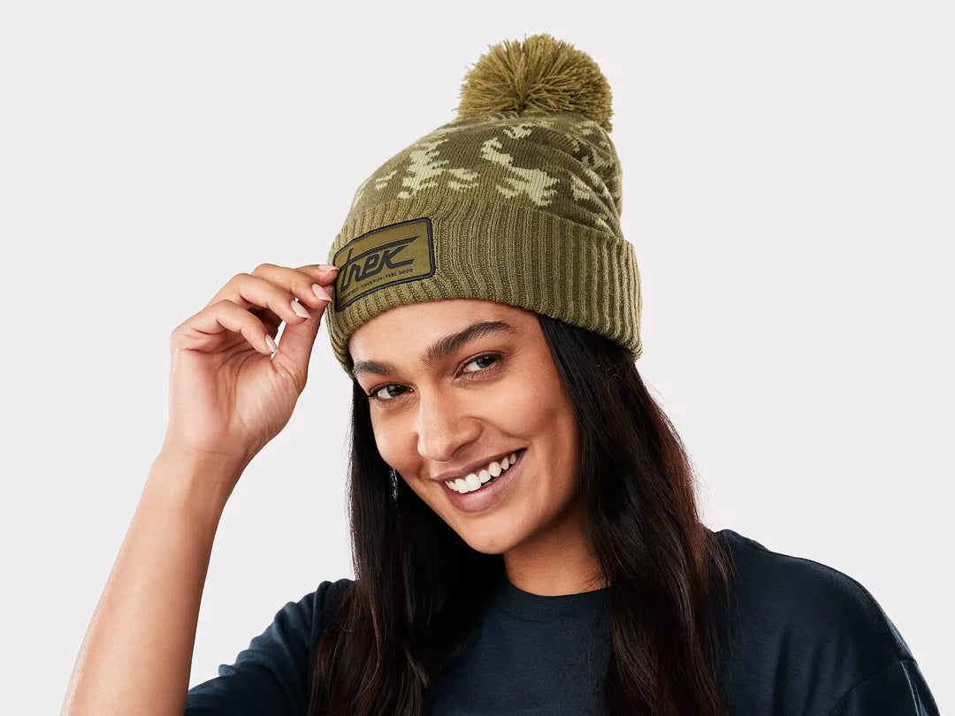 Olive camo beanie with pom and Trek logo, perfect for outdoor adventures and PNW style