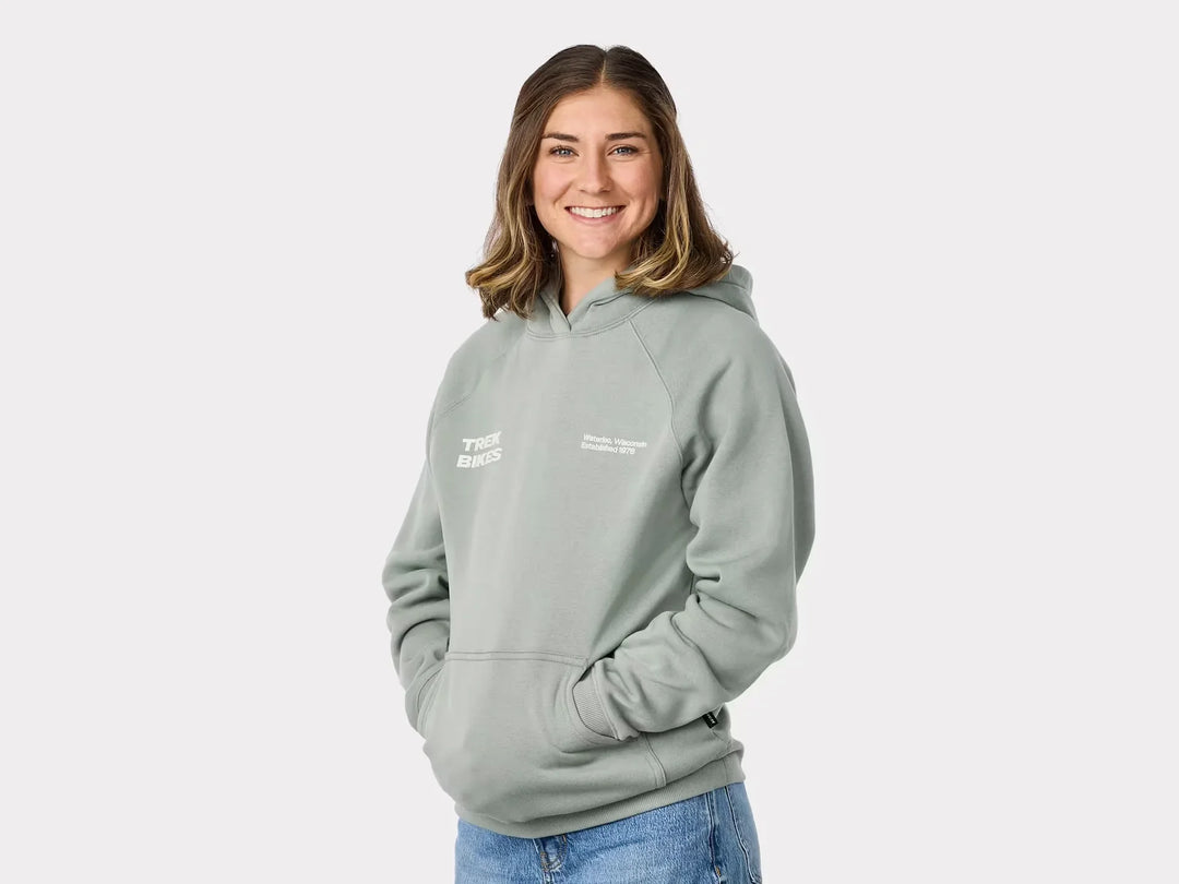 Woman wearing light green Trek Bikes hoodie with Wisconsin text, perfect for outdoor adventures and coastal style.