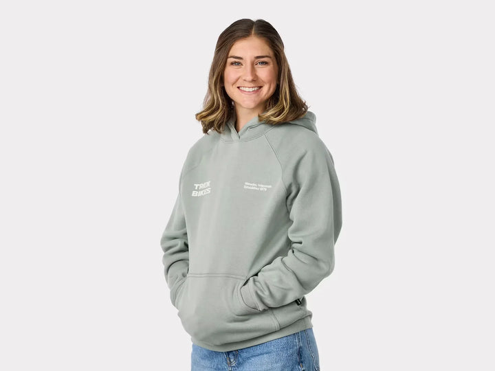 Woman wearing light green Trek Bikes hoodie with Wisconsin text, perfect for outdoor adventures and coastal style.