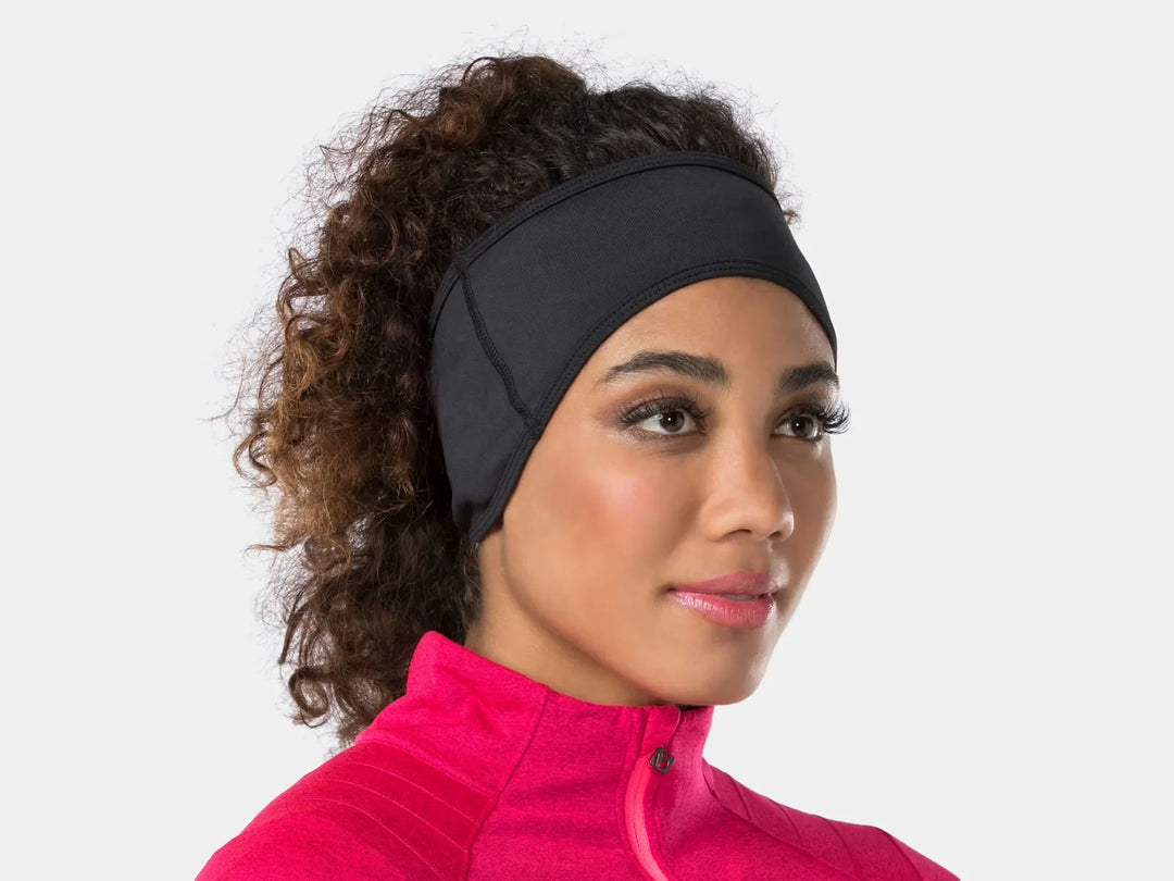 Woman wearing a black Trek Bontrager Thermal Cycling Headband and pink athletic top.
