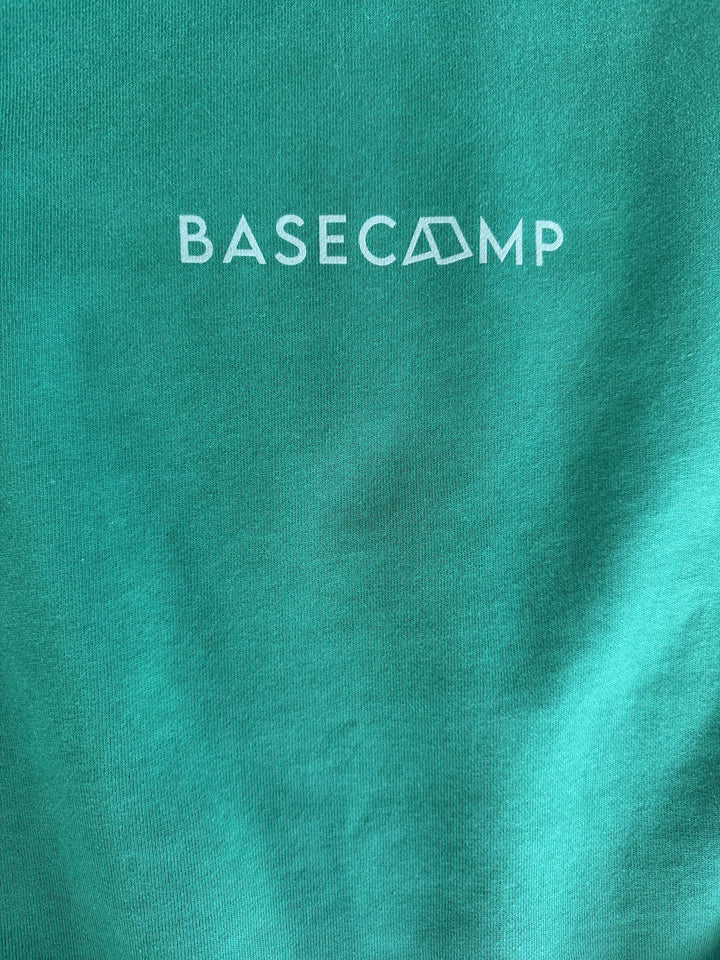 Green t-shirt with white Basecamp logo, perfect for outdoor adventures and coastal style.
