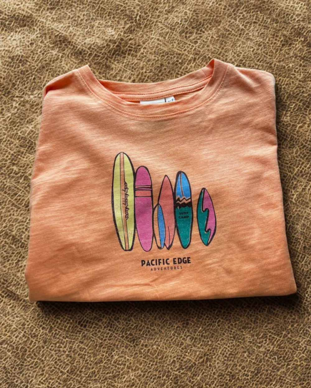 Peach t-shirt with colorful surfboard graphic and &