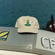 Beige cap with lighthouse logo on boat, coastal adventure gear for PNW weekends