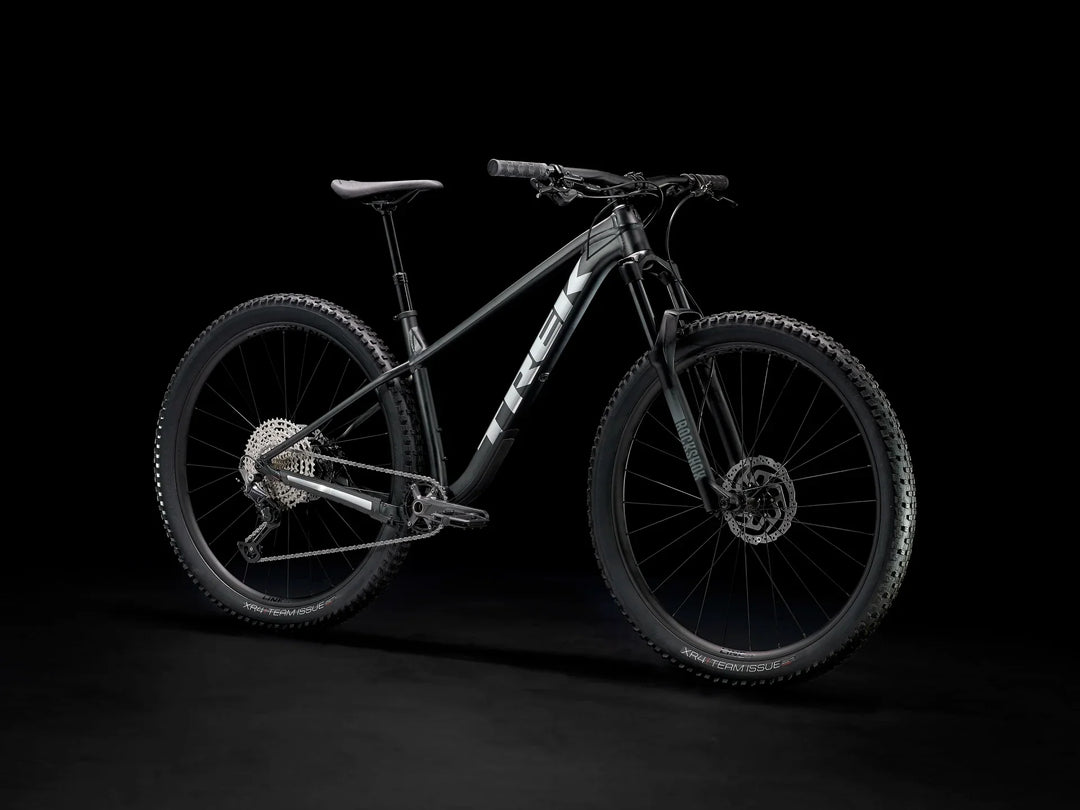 Black Trek mountain bike with RockShox suspension and XR4 Team Issue tires on dark background