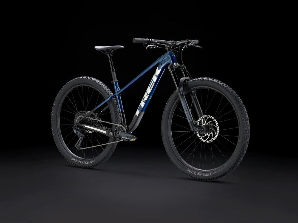 Blue Trek mountain bike with RockShox suspension and XR4 Team Issue tires on black background