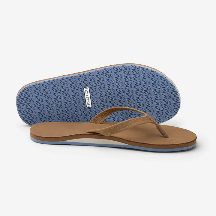 Tan flip flops with blue wavy sole, perfect for beach days and coastal adventures