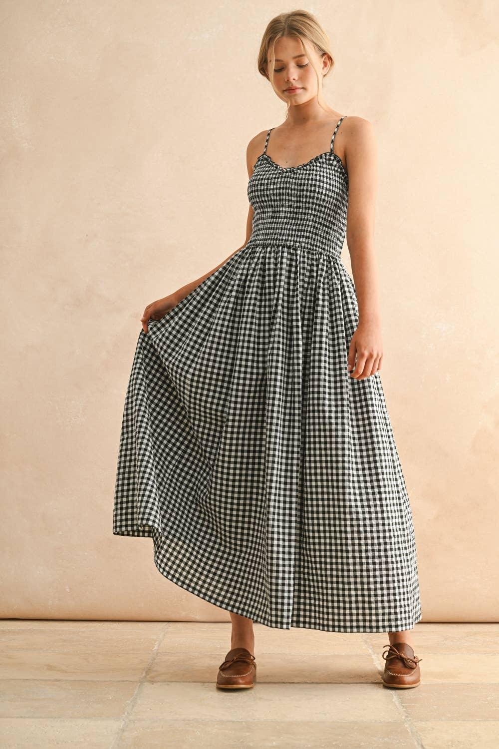Woman in black and white gingham maxi dress with spaghetti straps and brown loafers