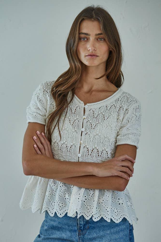 Cream lace peplum top with button front, paired with denim shorts for coastal style