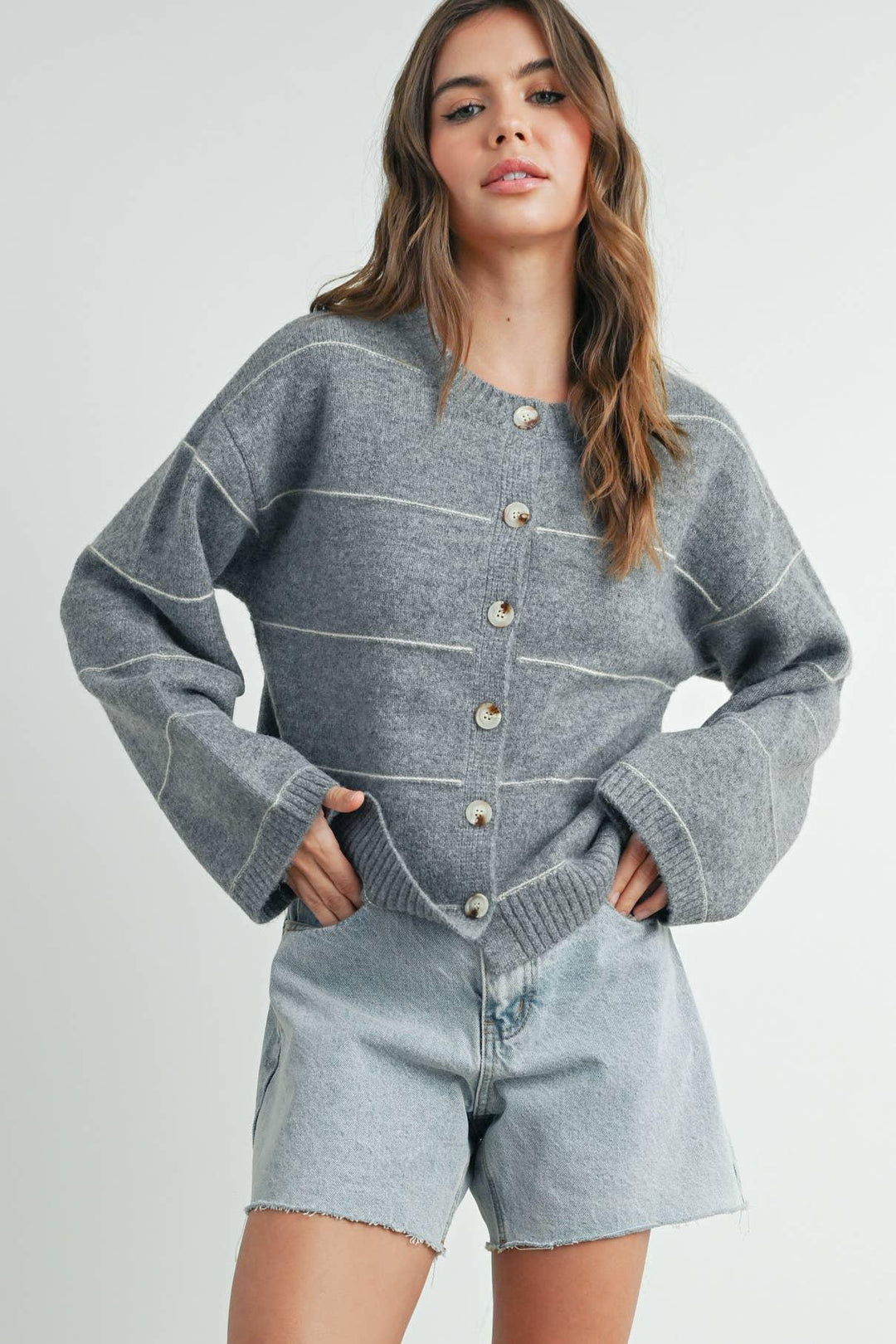 Gray striped button-up cardigan with bell sleeves paired with light wash denim shorts