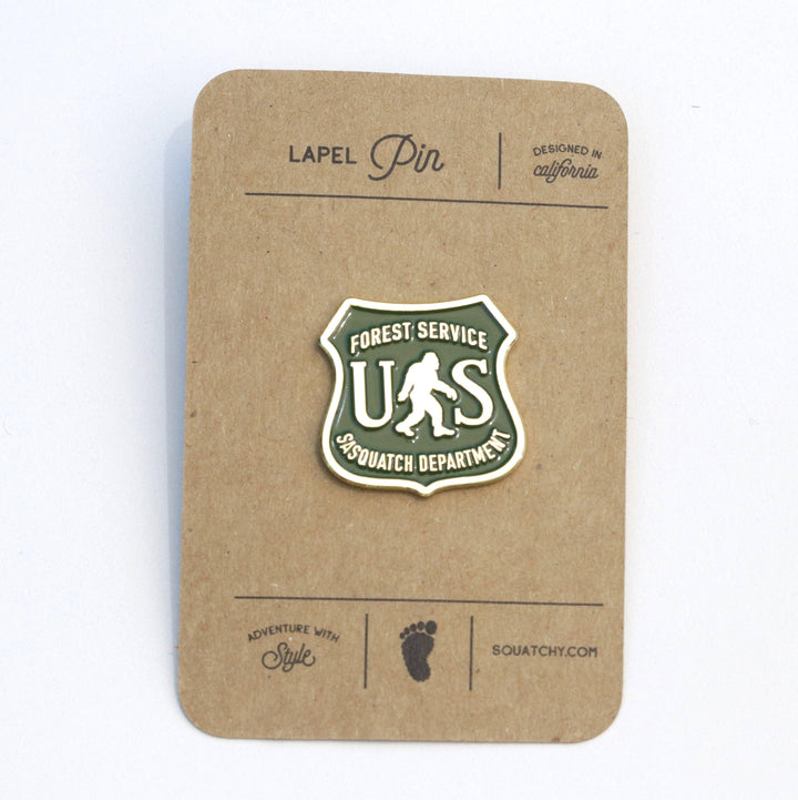Forest Service Sasquatch Department lapel pin, green shield design with bigfoot silhouette, adventure accessory