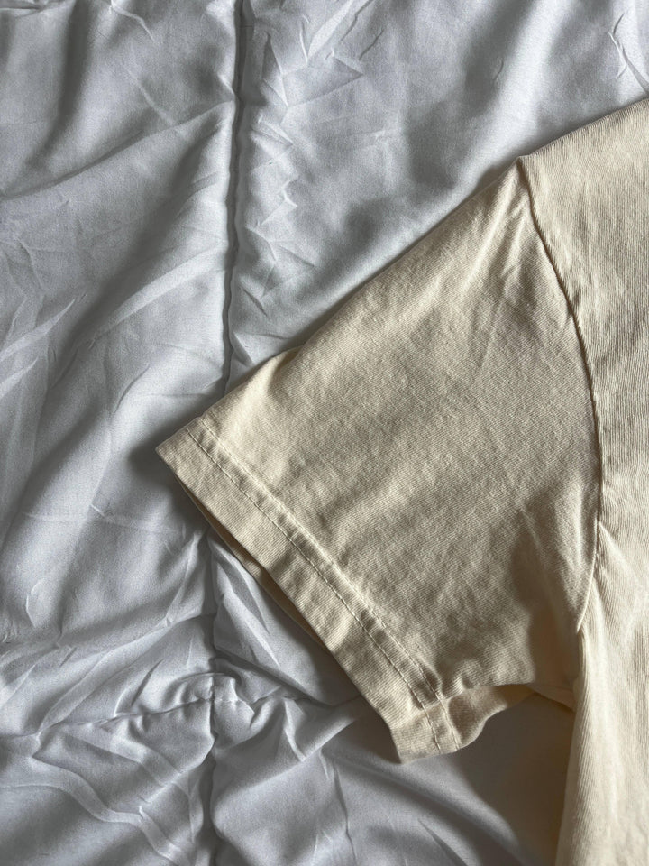 Cream cotton t-shirt sleeve detail on white fabric, coastal style everyday wear