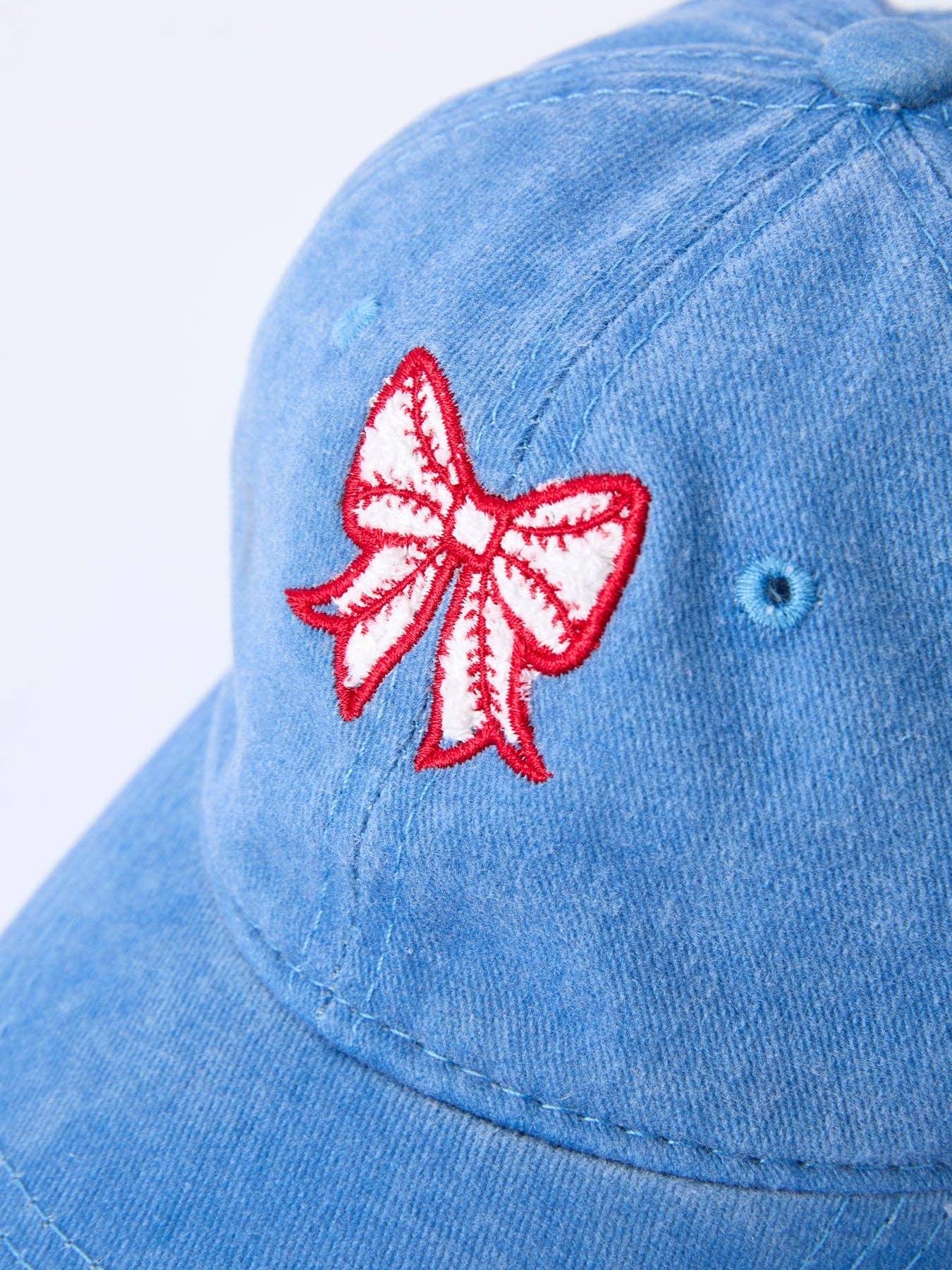 Light blue denim cap with red and white embroidered bow, perfect for coastal adventures and casual PNW style.