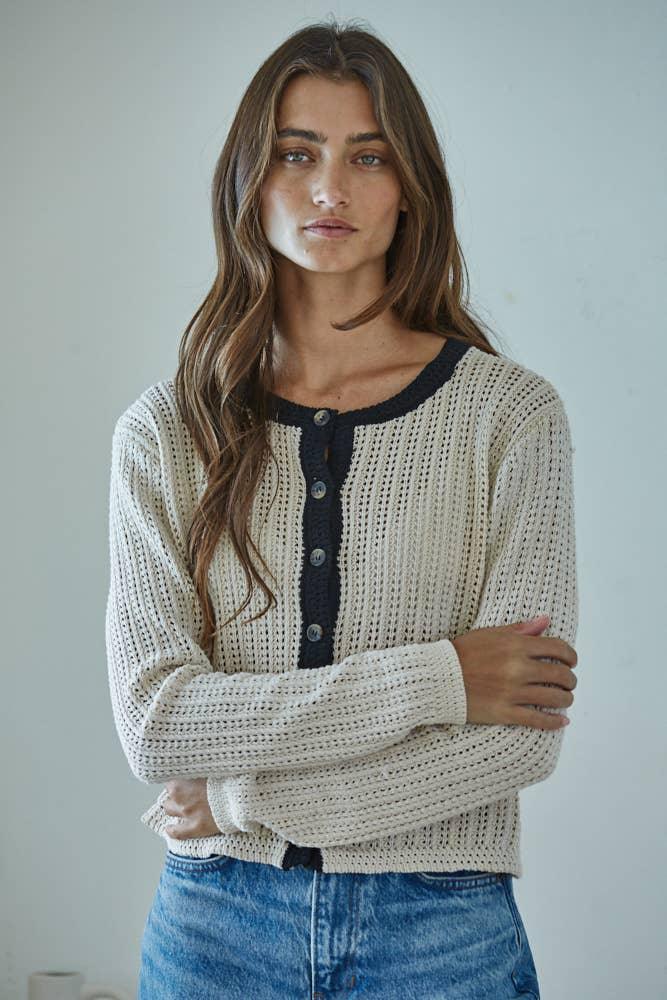 Cream knit cardigan with navy trim and buttons, paired with blue jeans for coastal PNW style
