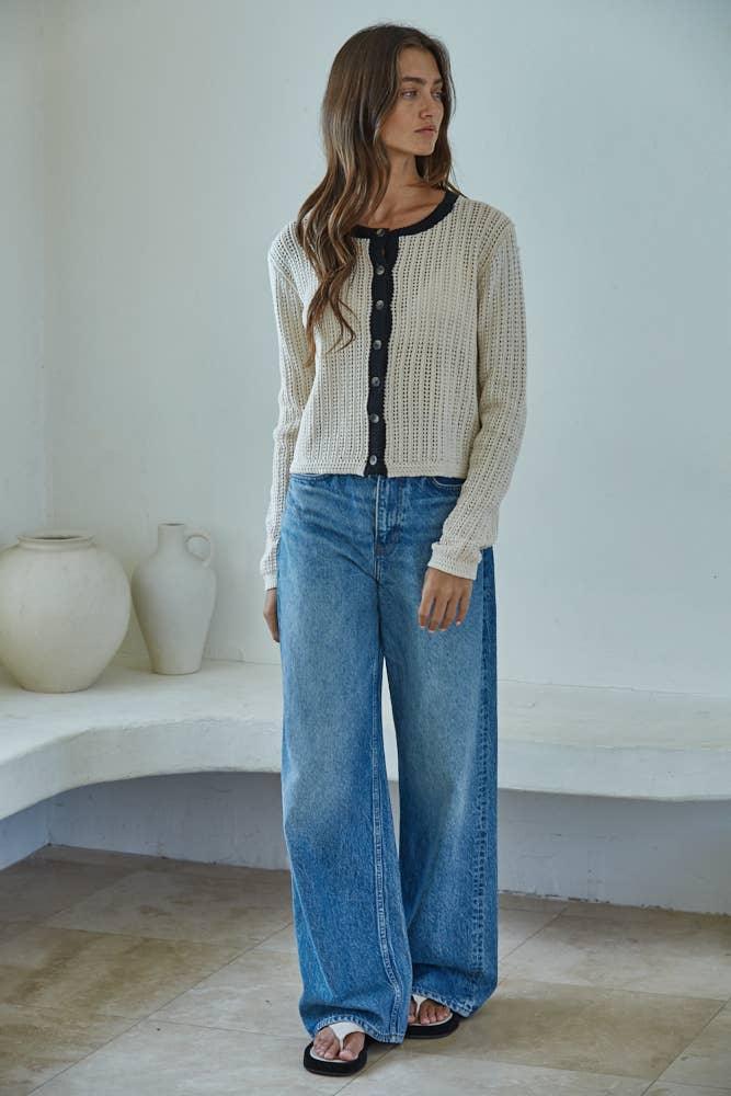 Cream knit cardigan with black trim, wide-leg denim jeans, coastal style outfit