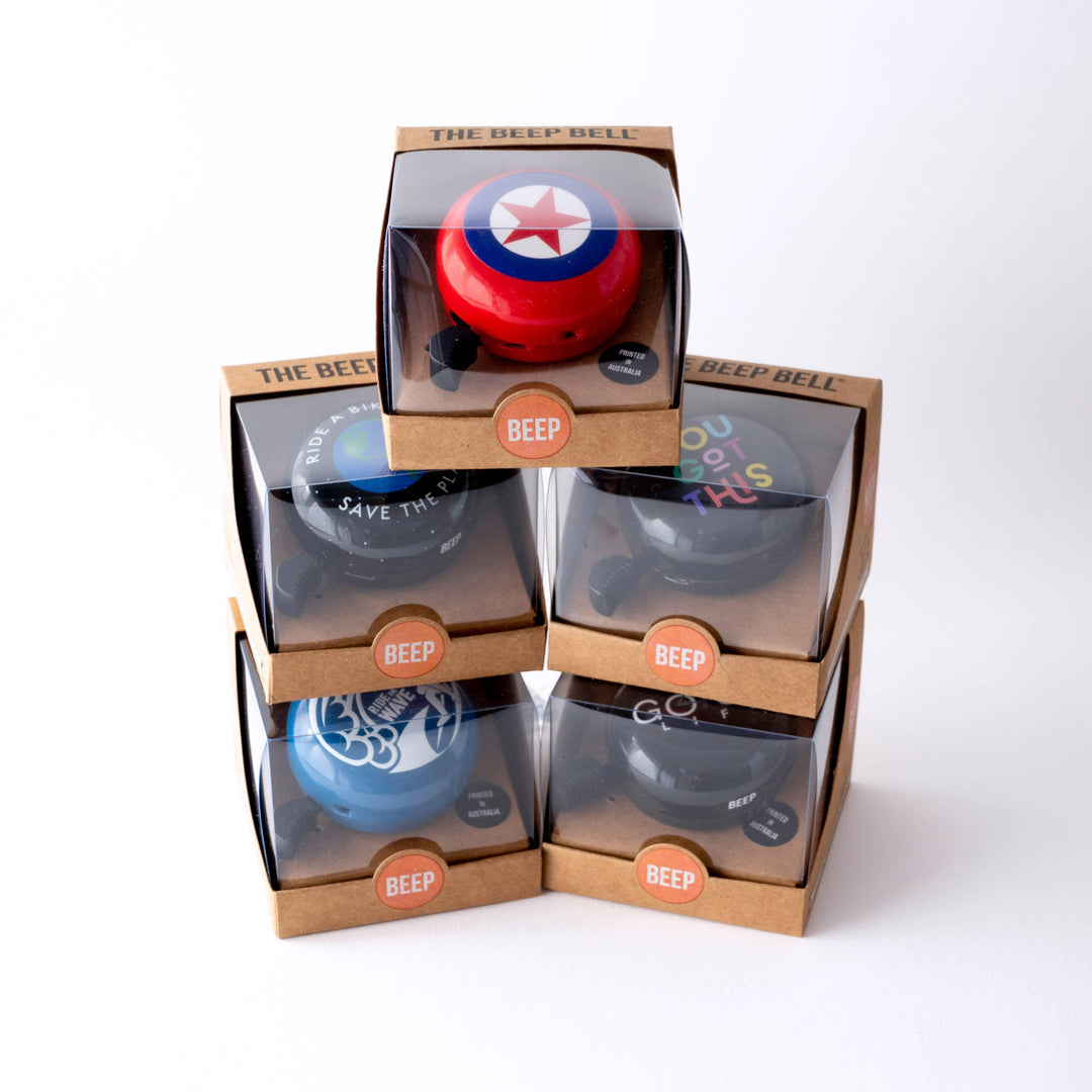 Colorful bike bells in retail boxes, perfect for coastal adventures and trail rides