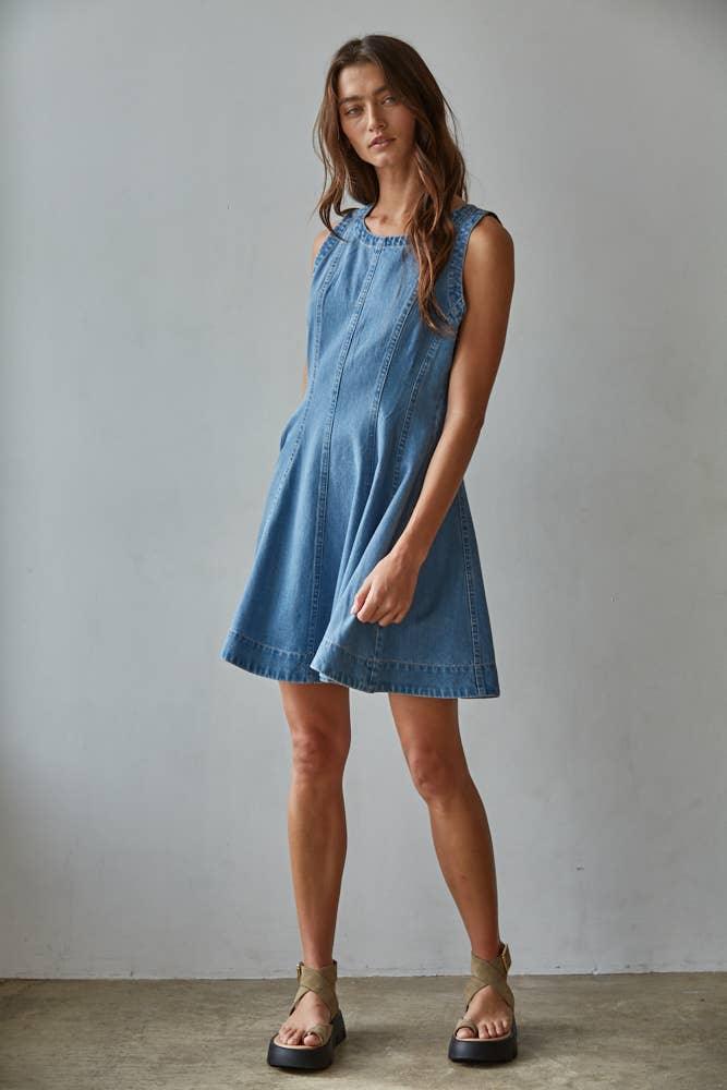 Woman in sleeveless denim dress with platform sandals, coastal style outfit