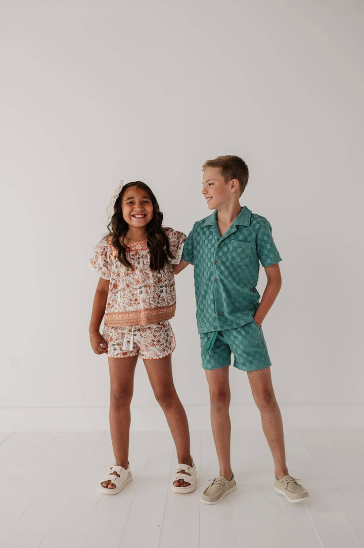 Kids in matching floral and checkered short sets for coastal summer adventures